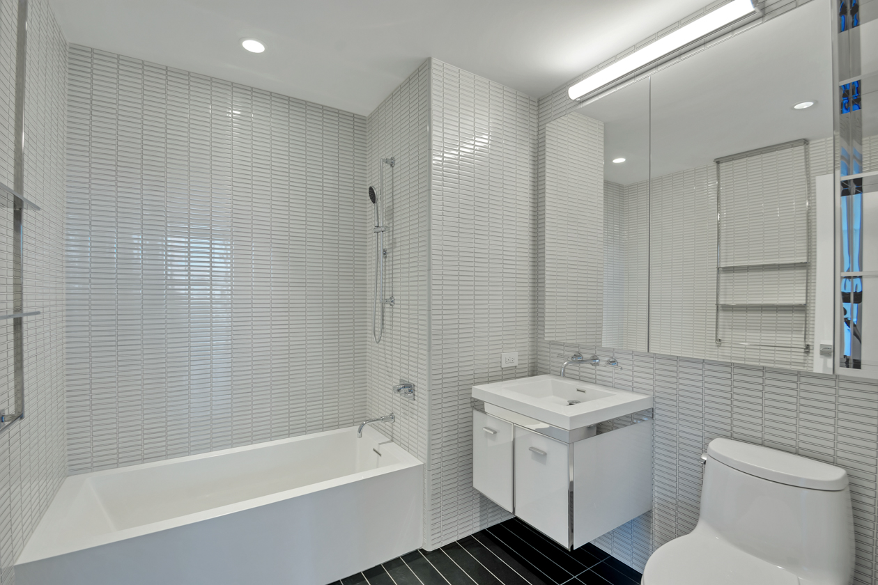 252 South Street, Unit 10K Manhattan, NY 10002 - Photo 4 of 19 a bathroom with a sink toilet a shower and bathtub