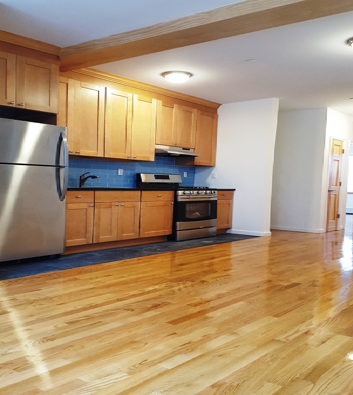 18-10 Astoria Park South, Unit 1 Queens, NY 11102 - Photo 2 of 7 a kitchen with stainless steel appliances granite countertop a refrigerator sink and cabinets