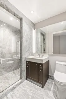 a bathroom with a sink vanity mirror and toilet