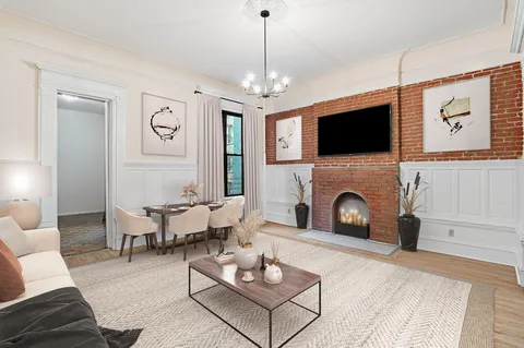 a living room with furniture a flat screen tv and a fireplace