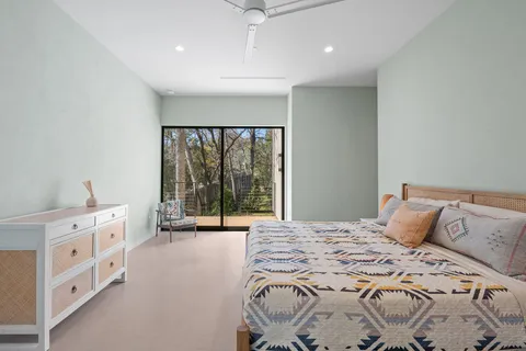 a large bedroom with a bed and a large window