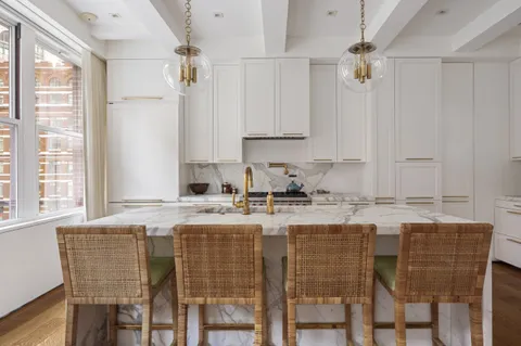 a kitchen with granite countertop a table chairs stove and cabinets