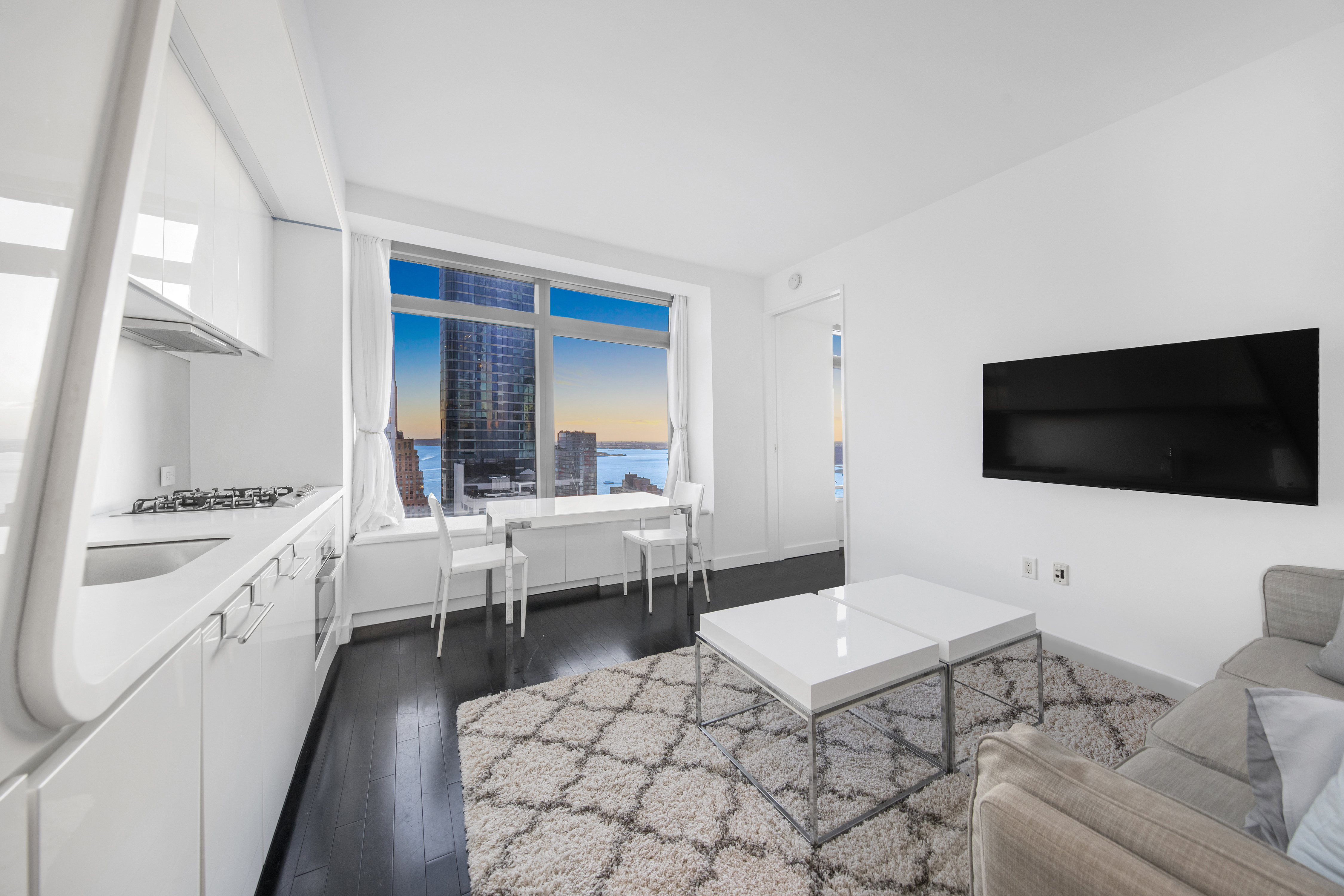 123 Washington Street, Unit 36H Manhattan, NY 10006 - Photo 3 of 8 a living room with furniture and a flat screen tv