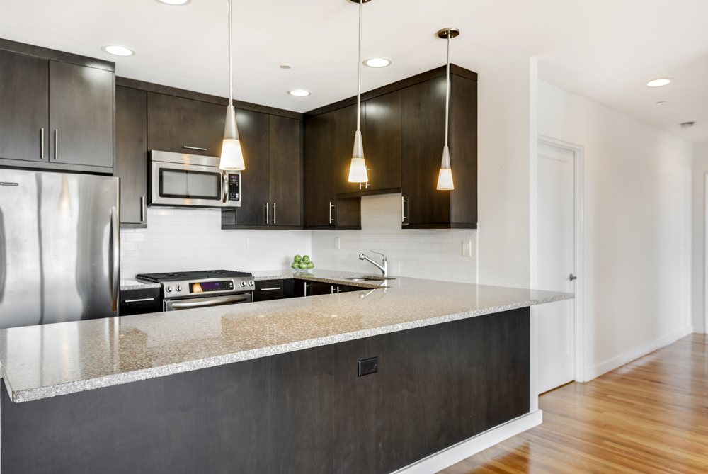 2098 Frederick Douglass Boulevard, Unit 7M Manhattan, NY 10026 - Photo 5 of 15 a kitchen with stainless steel appliances a sink a stove a refrigerator and cabinets