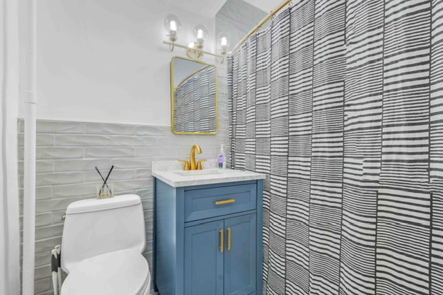 135 Ashland Place, Unit 5A Brooklyn, NY 11201 - Photo 6 of 12 a bathroom with a sink a toilet and mirror