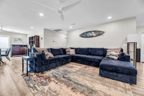 a living room with a couch and a dining table with wooden floor