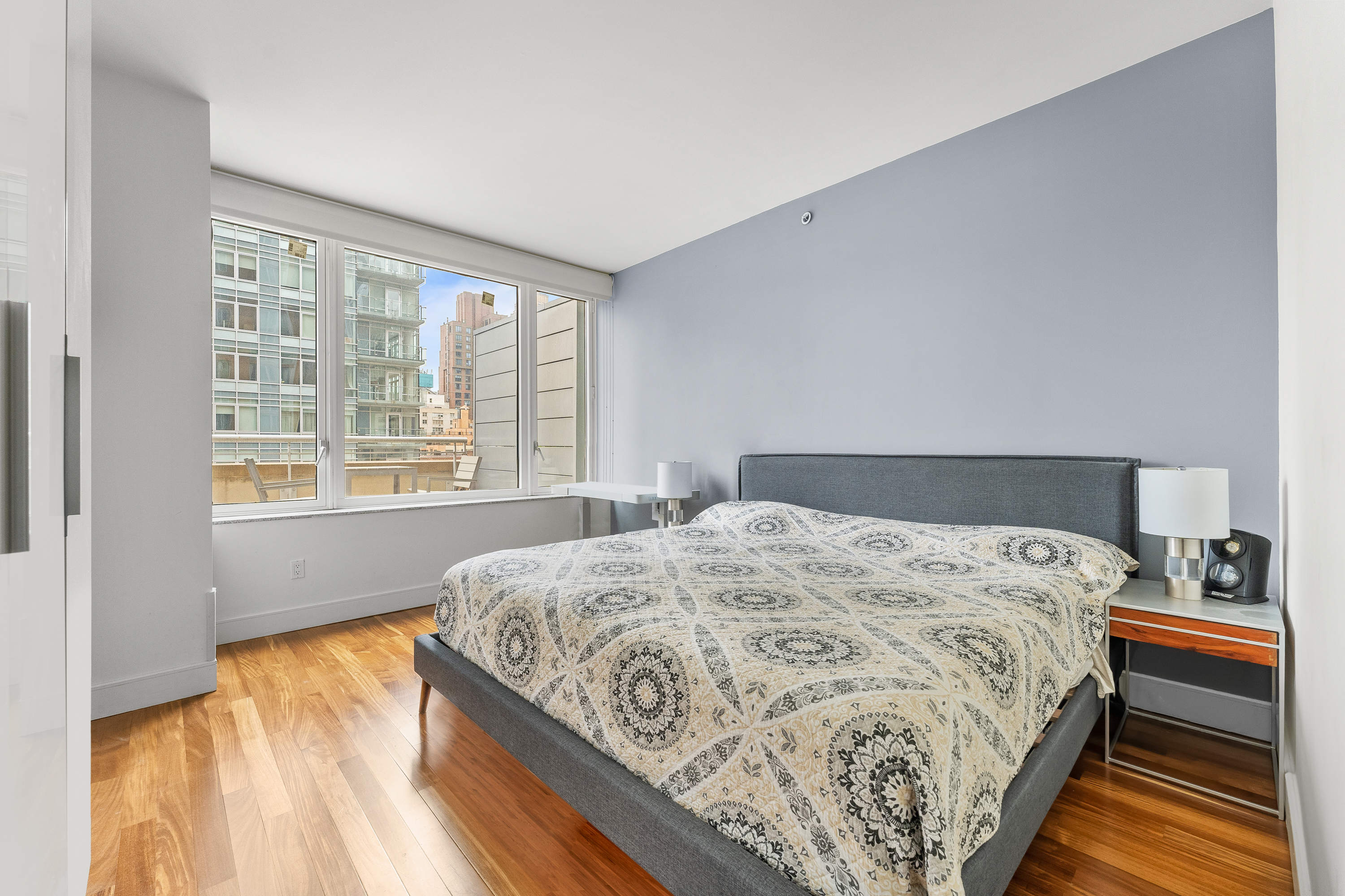 250 East 53rd Street, Unit 903 Manhattan, NY 10022 - Photo 6 of 8 a bedroom with a bed and wooden floor