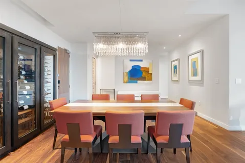 a dining room with furniture a chandelier and wooden floor
