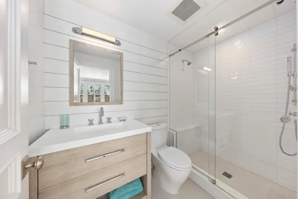 a bathroom with a double vanity sink toilet and shower