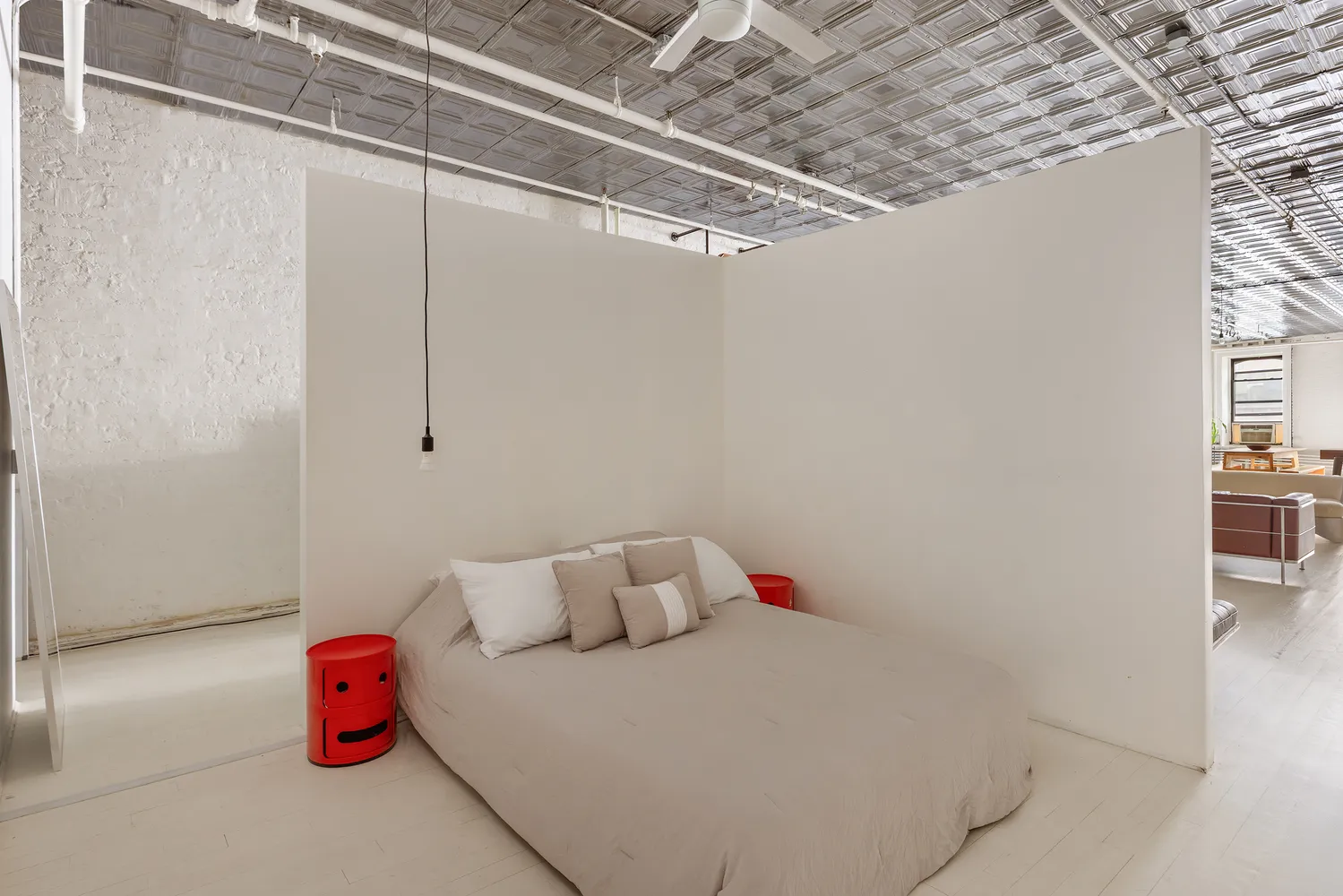 a bedroom with a bed and a table with potted plants