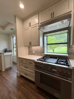 a kitchen with granite countertop a stove and a wooden floors