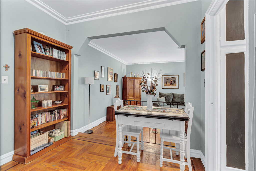 350 Cabrini Boulevard, Unit 6N Manhattan, NY 10040 - Photo 4 of 9 a dining room with a table and a bookshelf