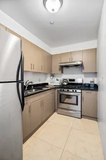 a kitchen with granite countertop a sink and white cabinets