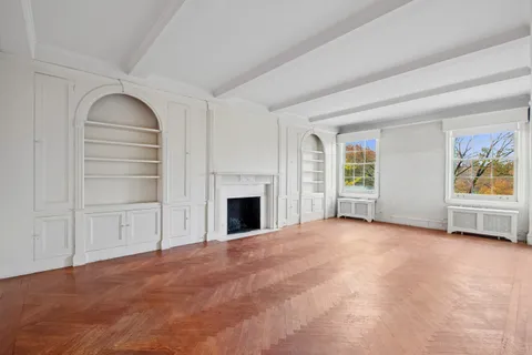 a view of an empty room with a fireplace and a window