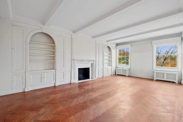 a view of an empty room with a fireplace and a window