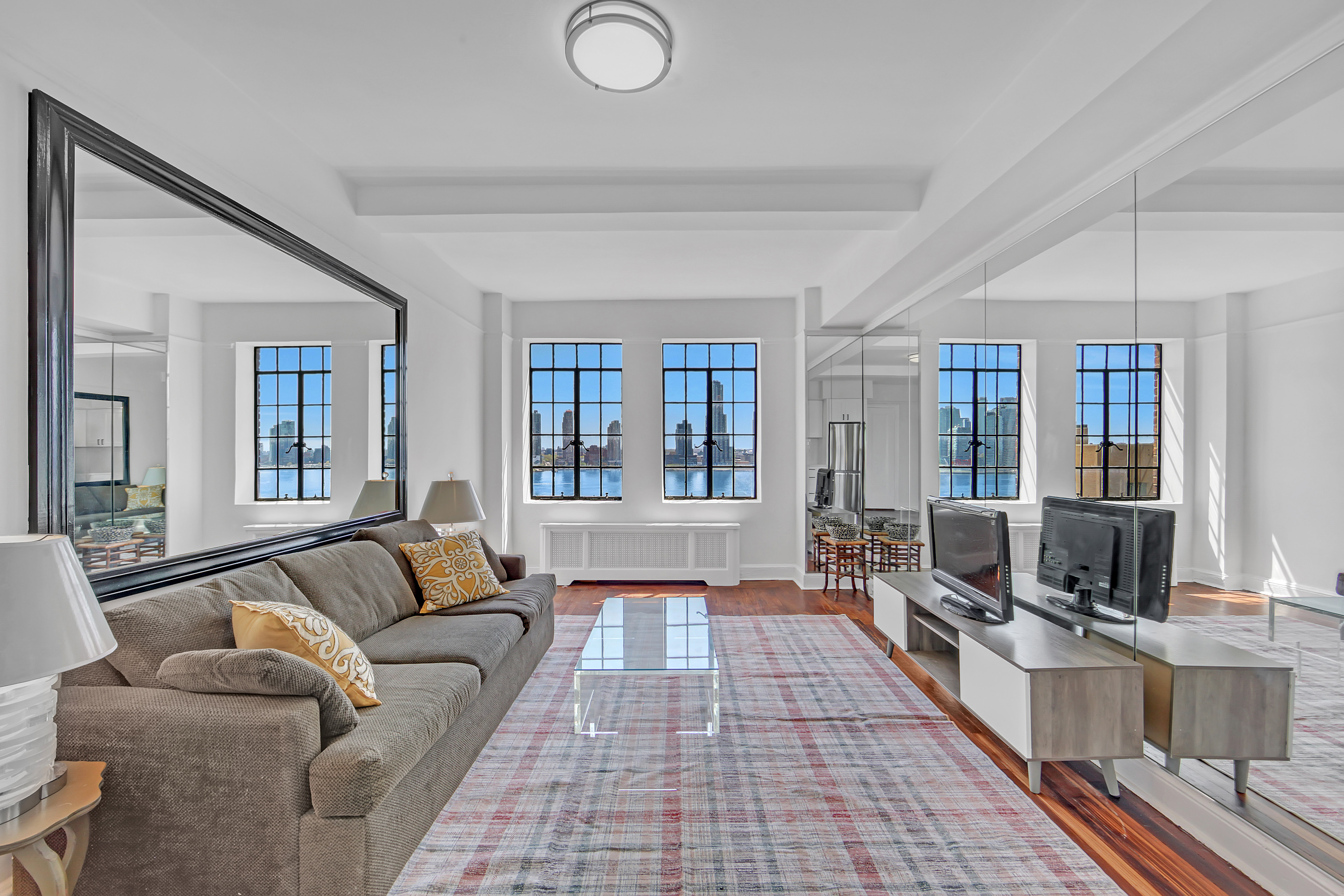 5 Tudor City Place, Unit 625 Manhattan, NY 10017 - Photo 2 of 11 a living room with furniture and a flat screen tv