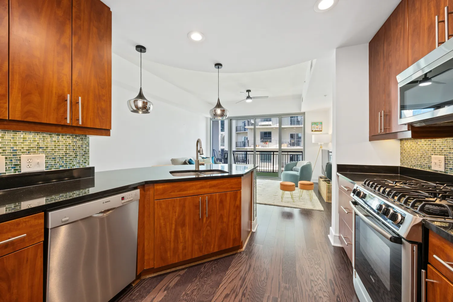 a kitchen with stainless steel appliances granite countertop a stove top oven a sink dishwasher and cabinets with wooden floor