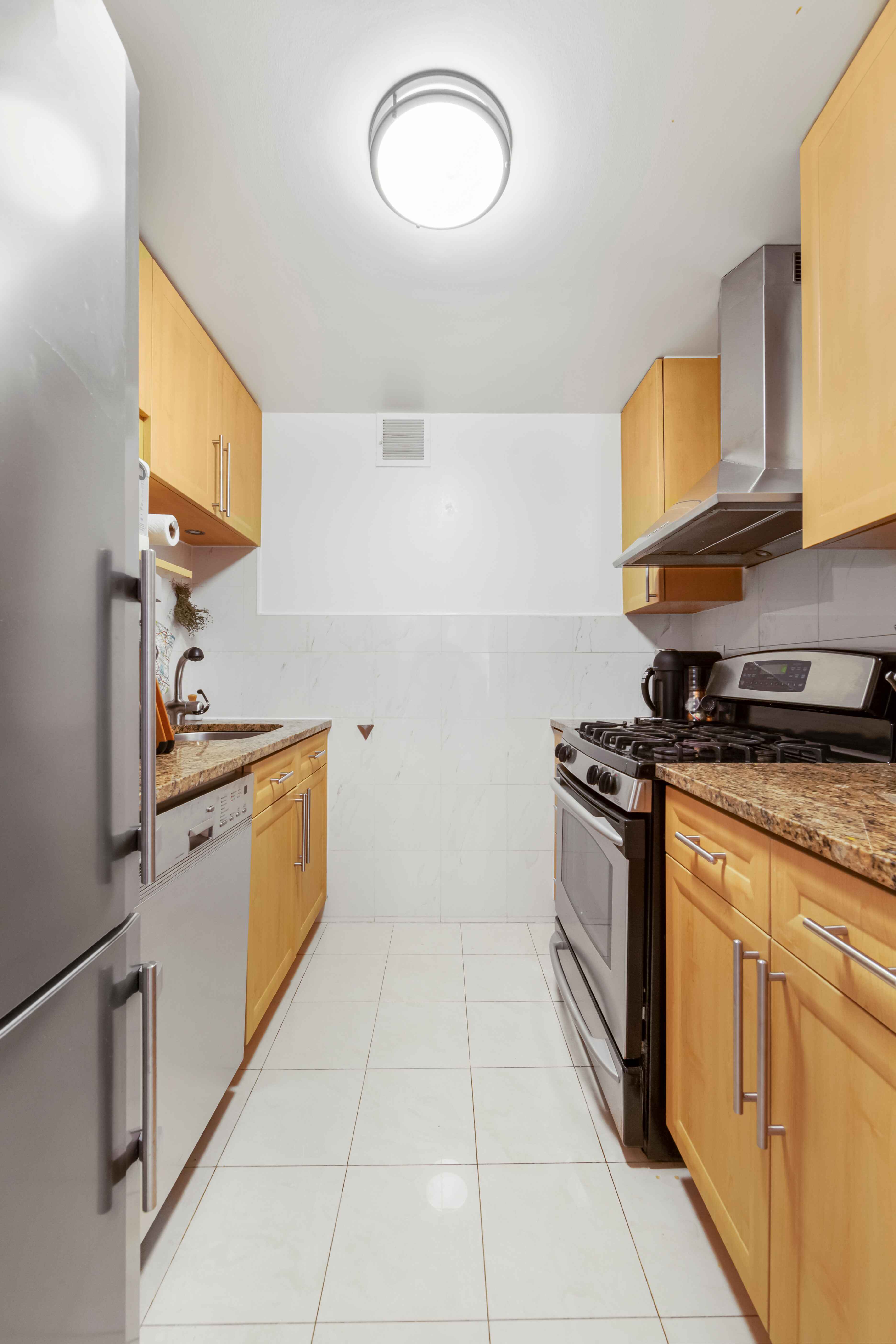 50 Lexington Avenue, Unit 10D Manhattan, NY 10010 - Photo 5 of 12 a kitchen with stainless steel appliances granite countertop a sink and a stove