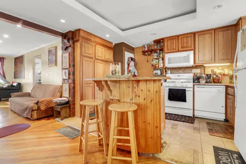 a living room with stainless steel appliances furniture and a kitchen view