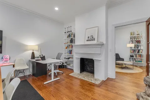 a living room with furniture a fireplace and a bookshelf
