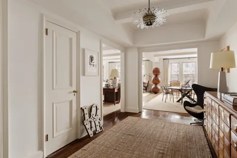 a living room with furniture a chandelier and a window