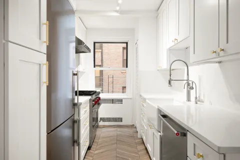 a kitchen with stainless steel appliances granite countertop a sink and a refrigerator