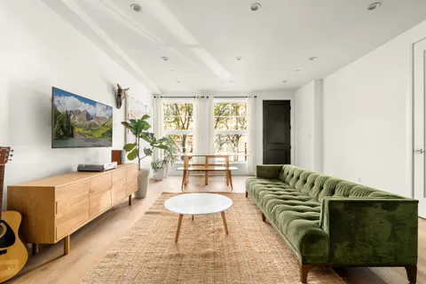 a living room with furniture a flat screen tv and a large window