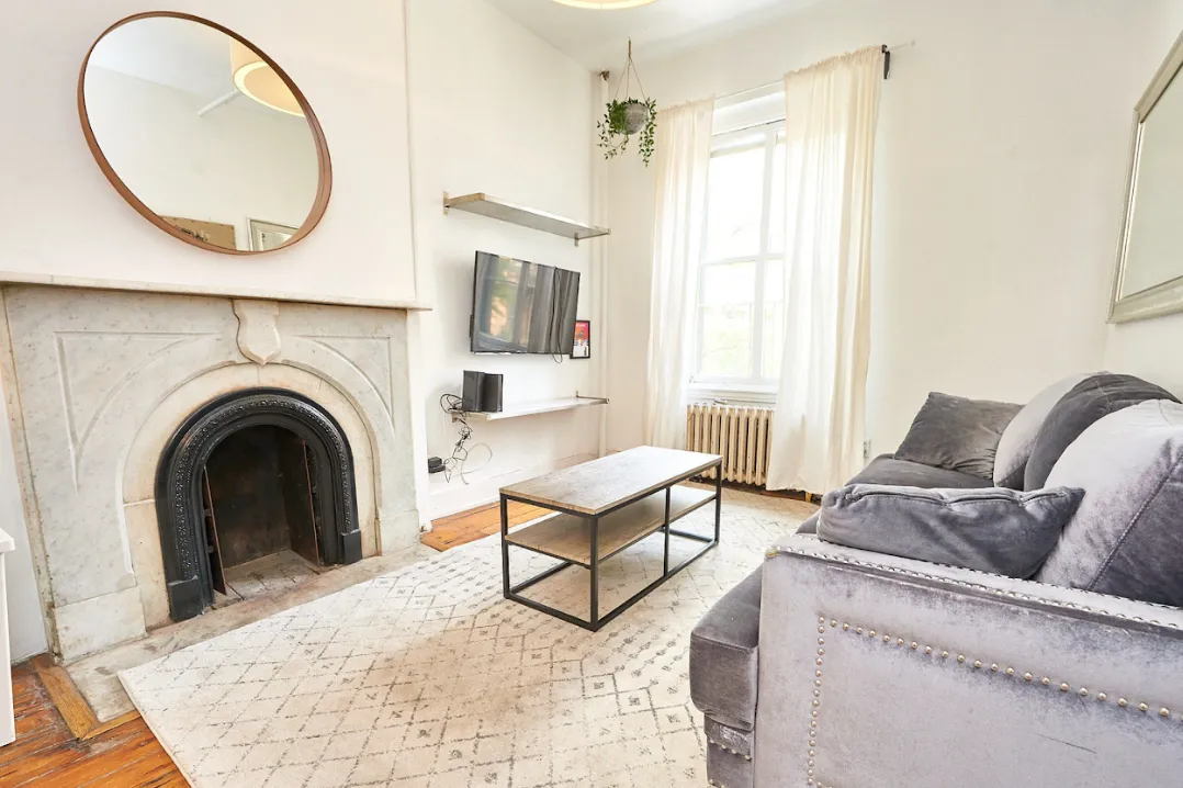a living room with furniture a mirror and a fireplace