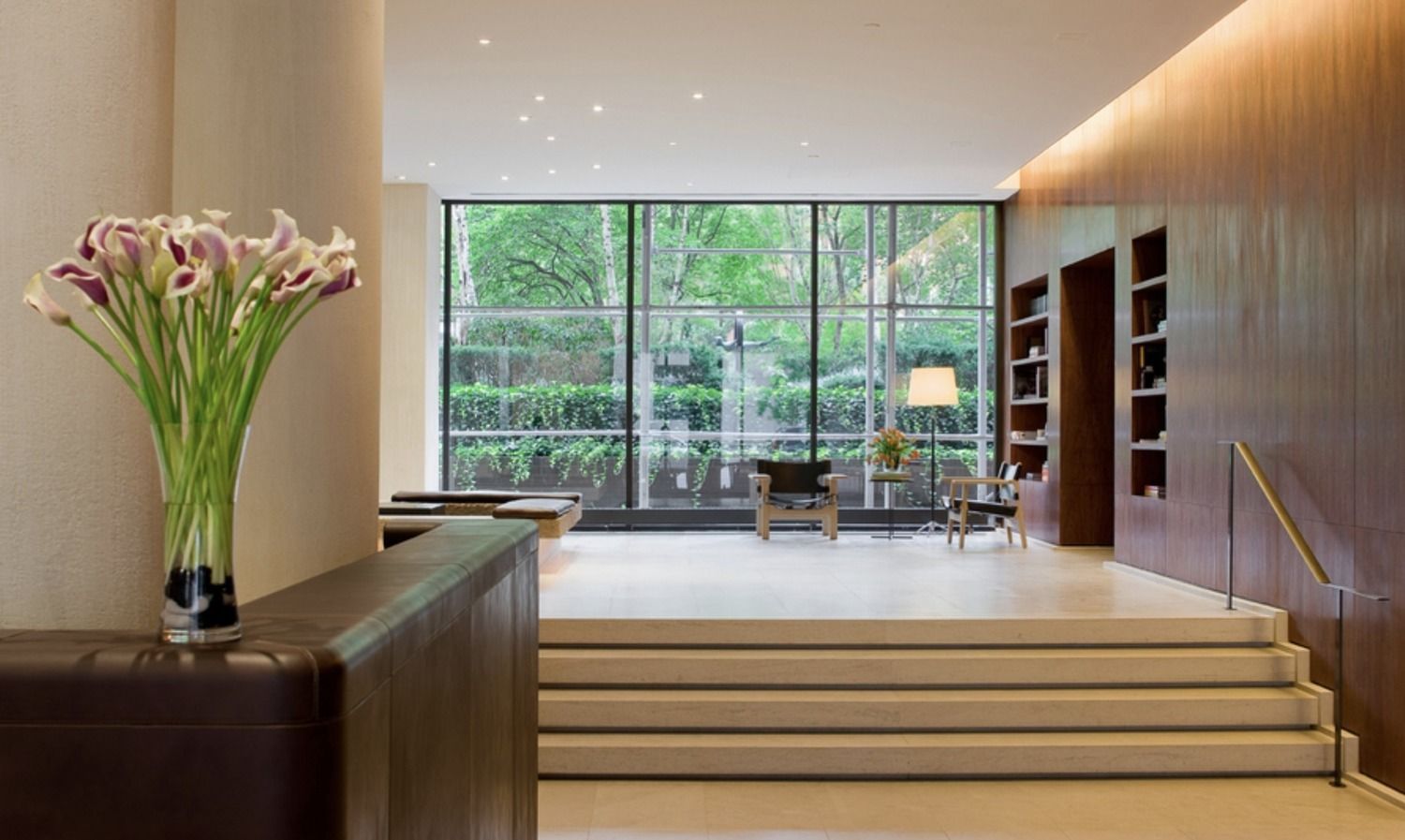 a lobby with a floor to ceiling window and a potted plant