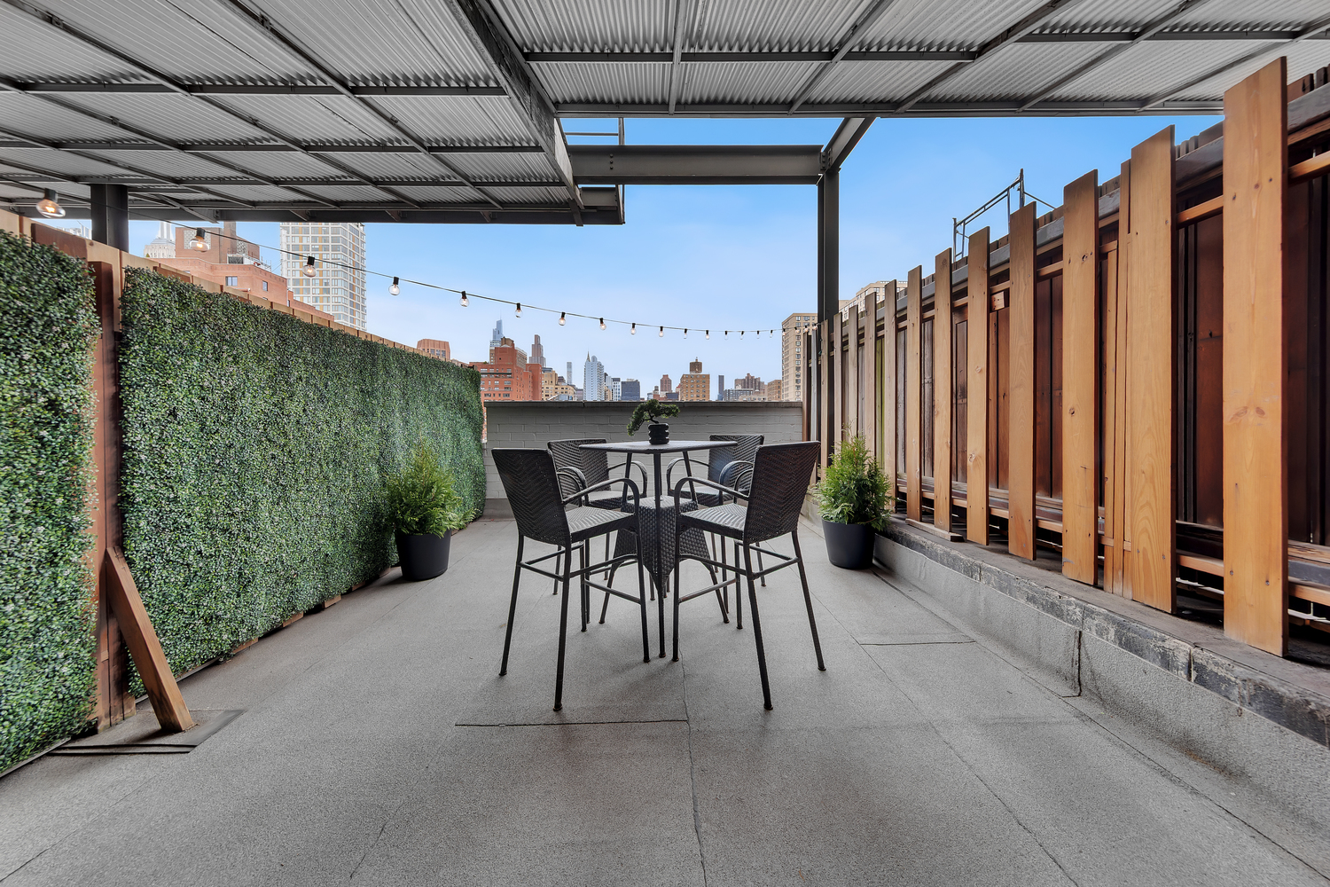 215 East 24th Street, Unit 602 Manhattan, NY 10010 - Photo 1 of 8 a view of a patio with table and chairs and wooden fence