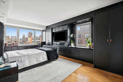 a bedroom with a bed and a flat tv screen on the dresser