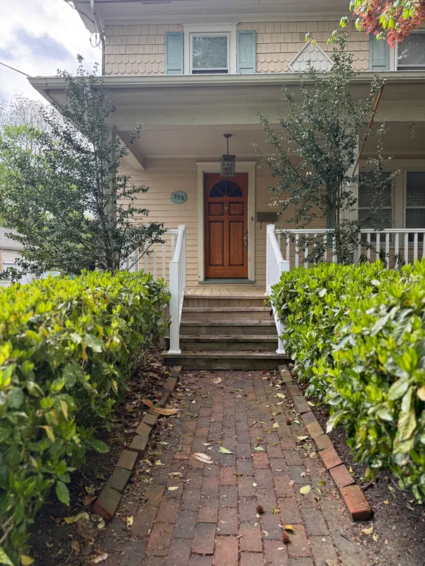 a front view of a house with plants