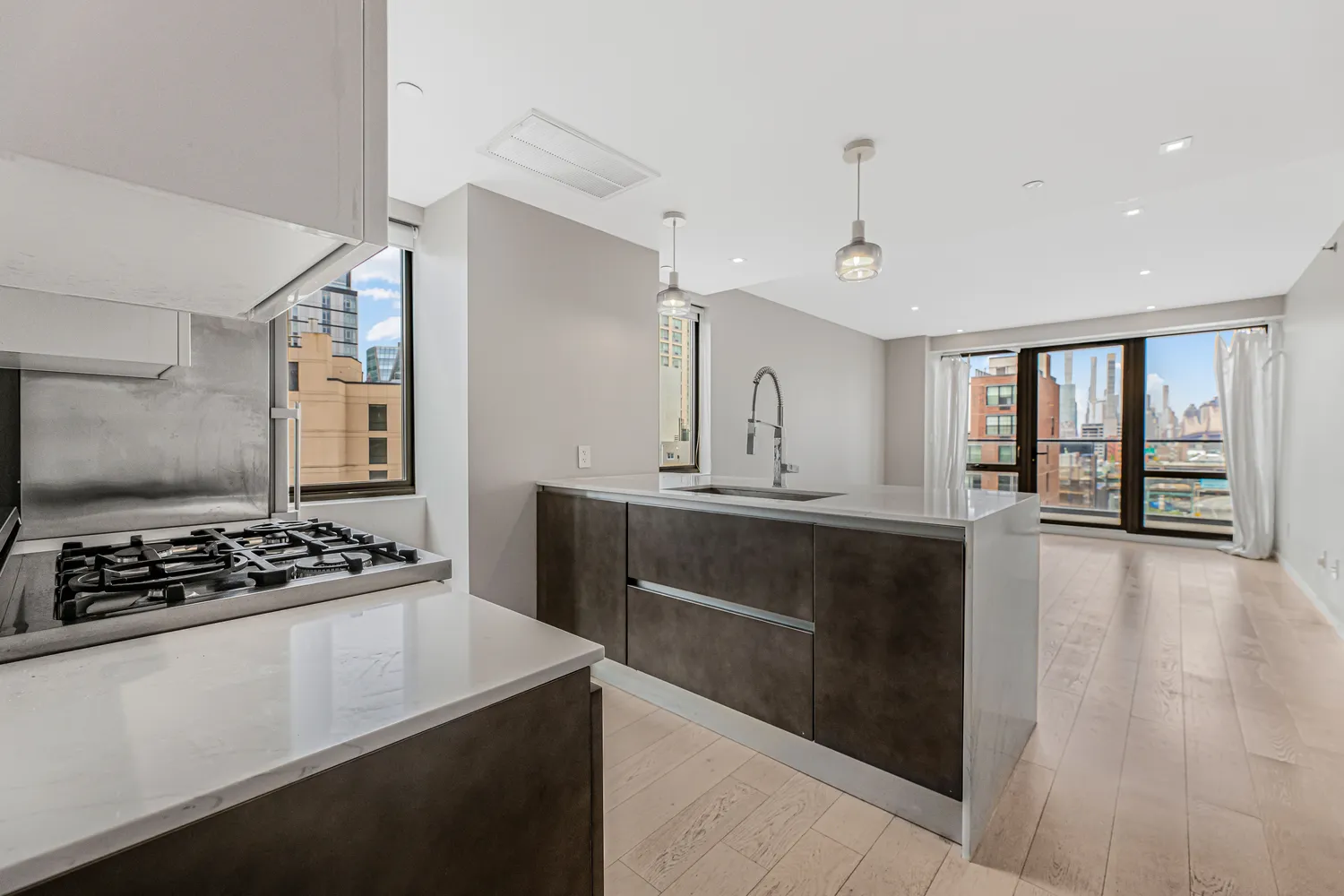 a kitchen with kitchen island stainless steel appliances a sink stove and window