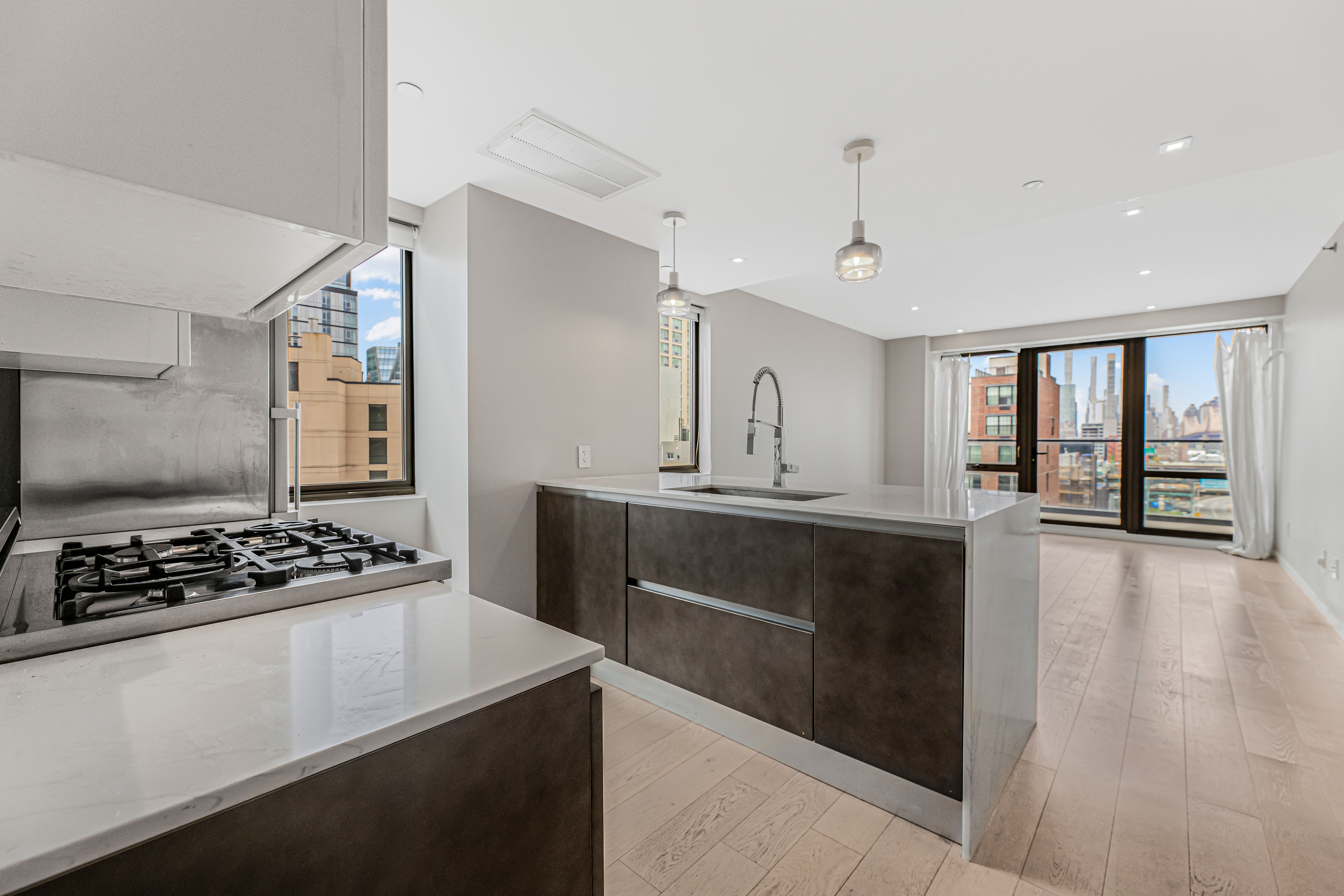 42-50 27th Street, Unit 9C Queens, NY 11101 - Photo 1 of 32 a kitchen with kitchen island stainless steel appliances a sink stove and window