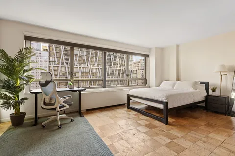 a spacious bedroom with a bed and a table in it