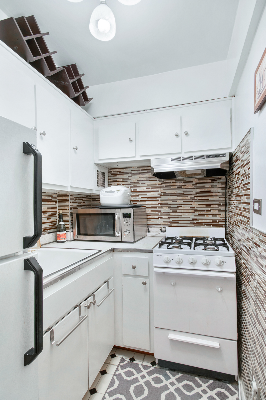 335 East 51st Street, Unit 10C Manhattan, NY 10022 - Photo 4 of 9 a kitchen with a stove cabinets and wooden floor