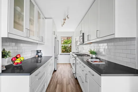 a kitchen with granite countertop a sink stove and cabinets