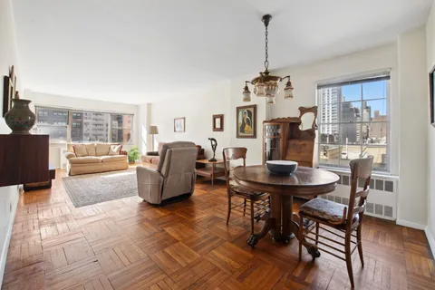 a living room with furniture a dining table and a window