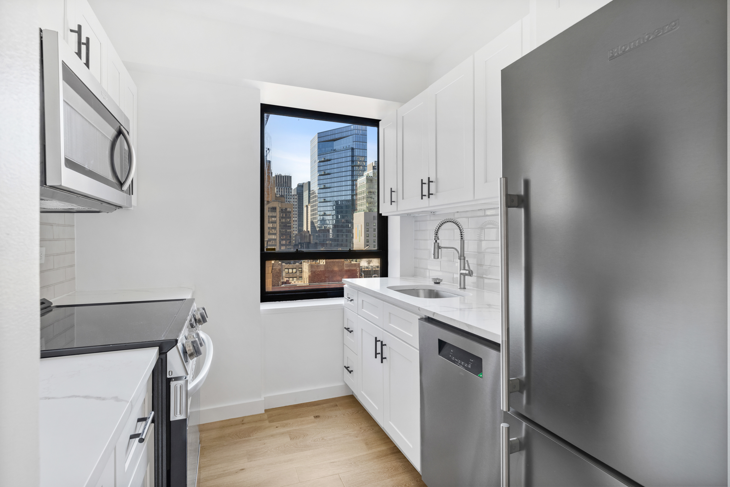240 East 47th Street, Unit 27A Manhattan, NY 10017 - Photo 3 of 9 a kitchen with a sink and a refrigerator