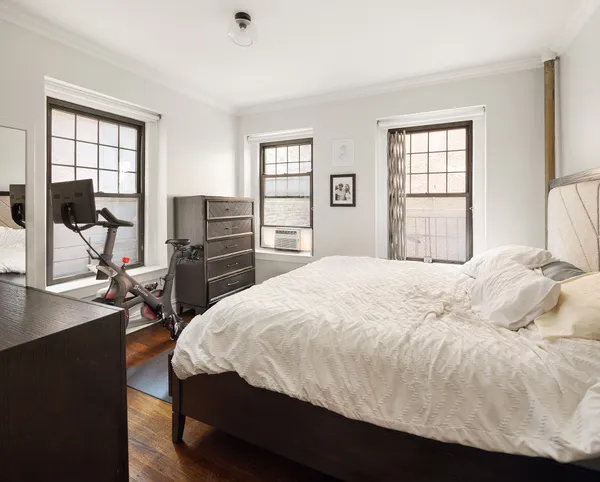 a bedroom with a bed and a flat tv screen on the dresser