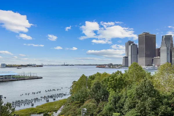 a view of a lake with a big yard and large trees