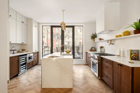 a large kitchen with stainless steel appliances granite countertop a stove a sink and a refrigerator