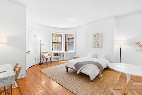 a bedroom with a bed a table and chair