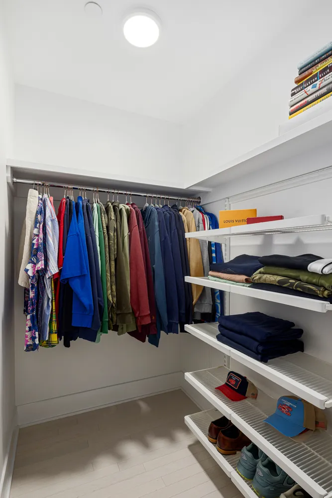 a view of walk in closet with clothes and shoes