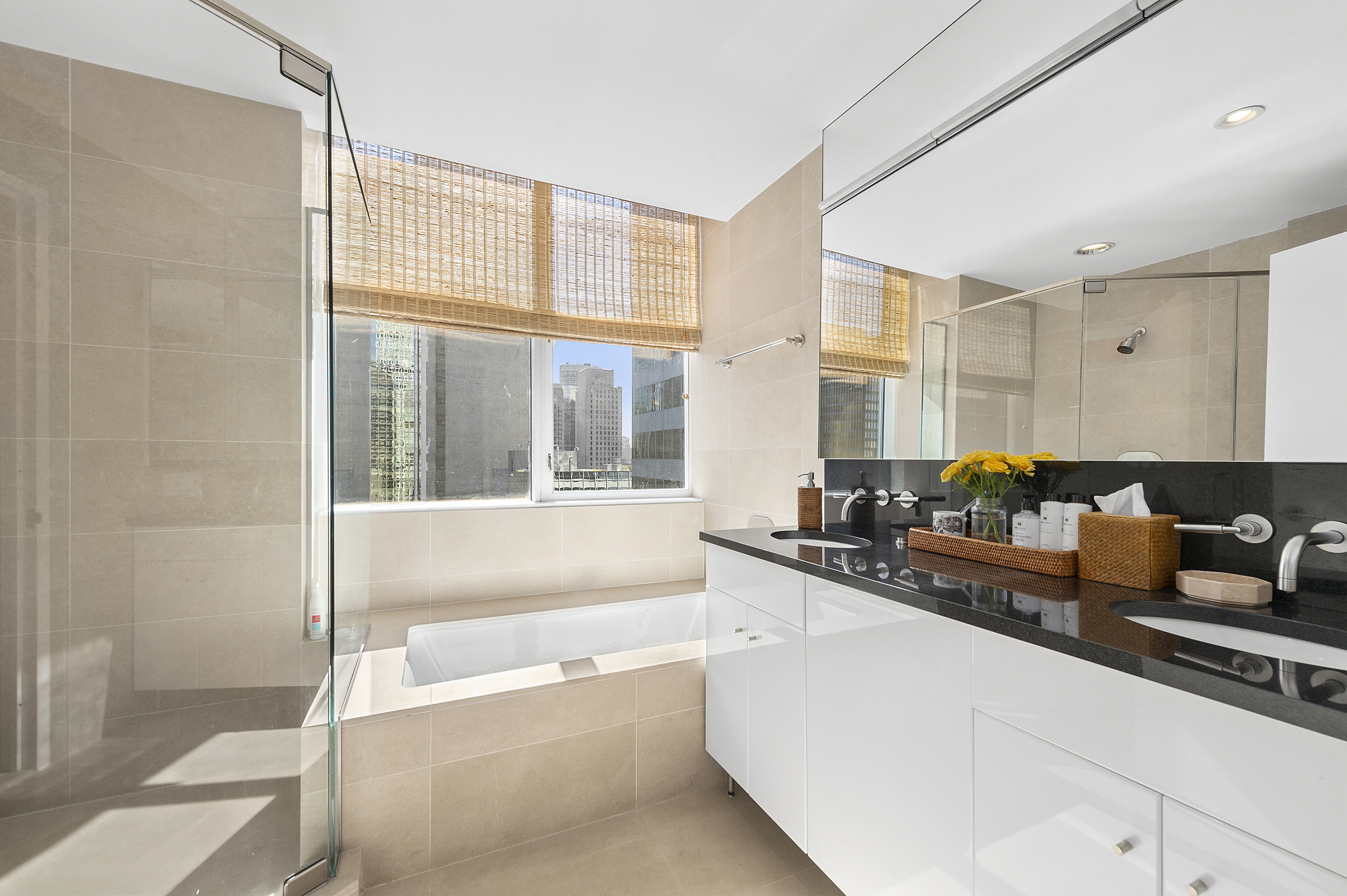 60 East 55th Street, Unit 40B Manhattan, NY 10022 - Photo 3 of 12 a large white kitchen with granite countertop a sink and a large window