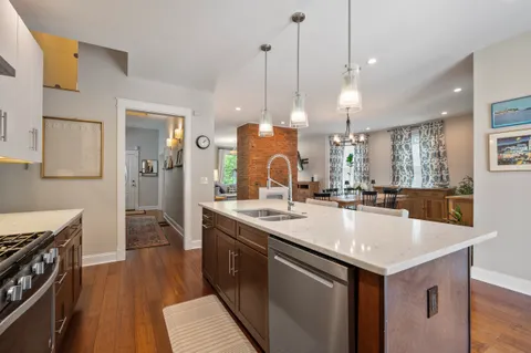a kitchen with a sink a counter space and wooden floor
