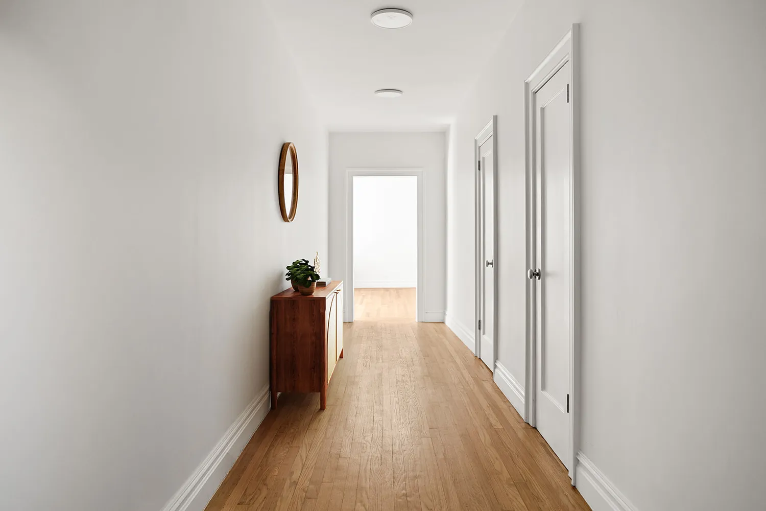 a view of a hallway with wooden floor and stairs