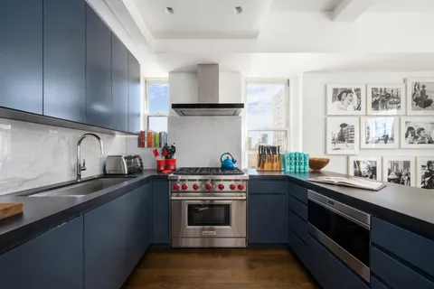 a kitchen with stainless steel appliances a sink a stove and cabinets