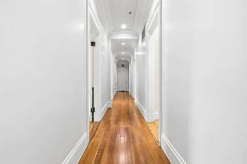 a view of a hallway with wooden floor
