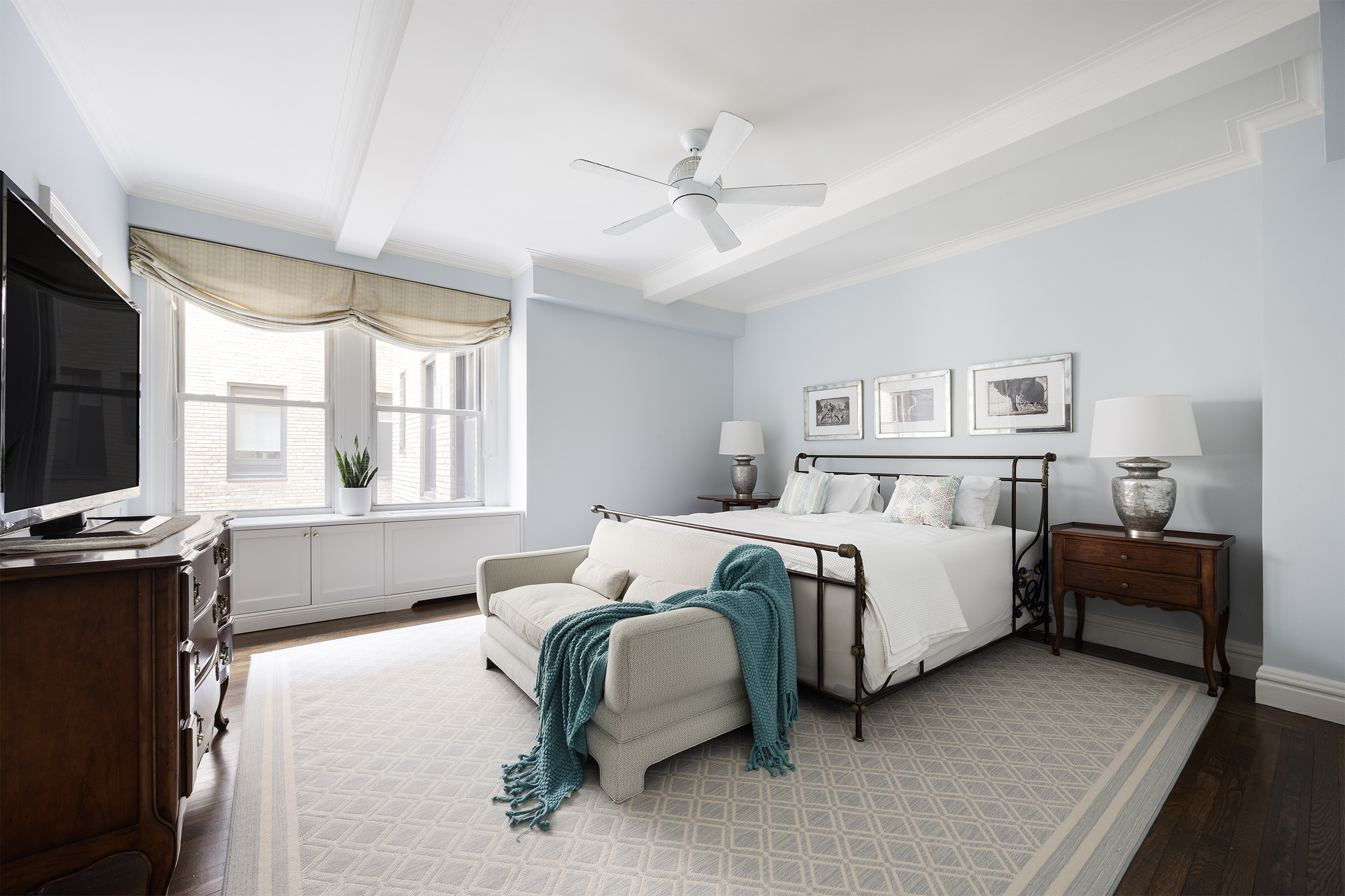 21 East 87th Street, Unit 10D Manhattan, NY 10128 - Photo 6 of 11 a bedroom with a bed and a chandelier